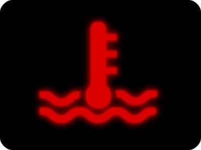 The engine temperature warning light glowing on a Mini Cooper's instrument panel