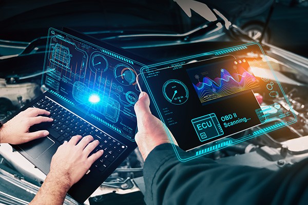 Mechanic using diagnostic software on a laptop to check a car's electrical system