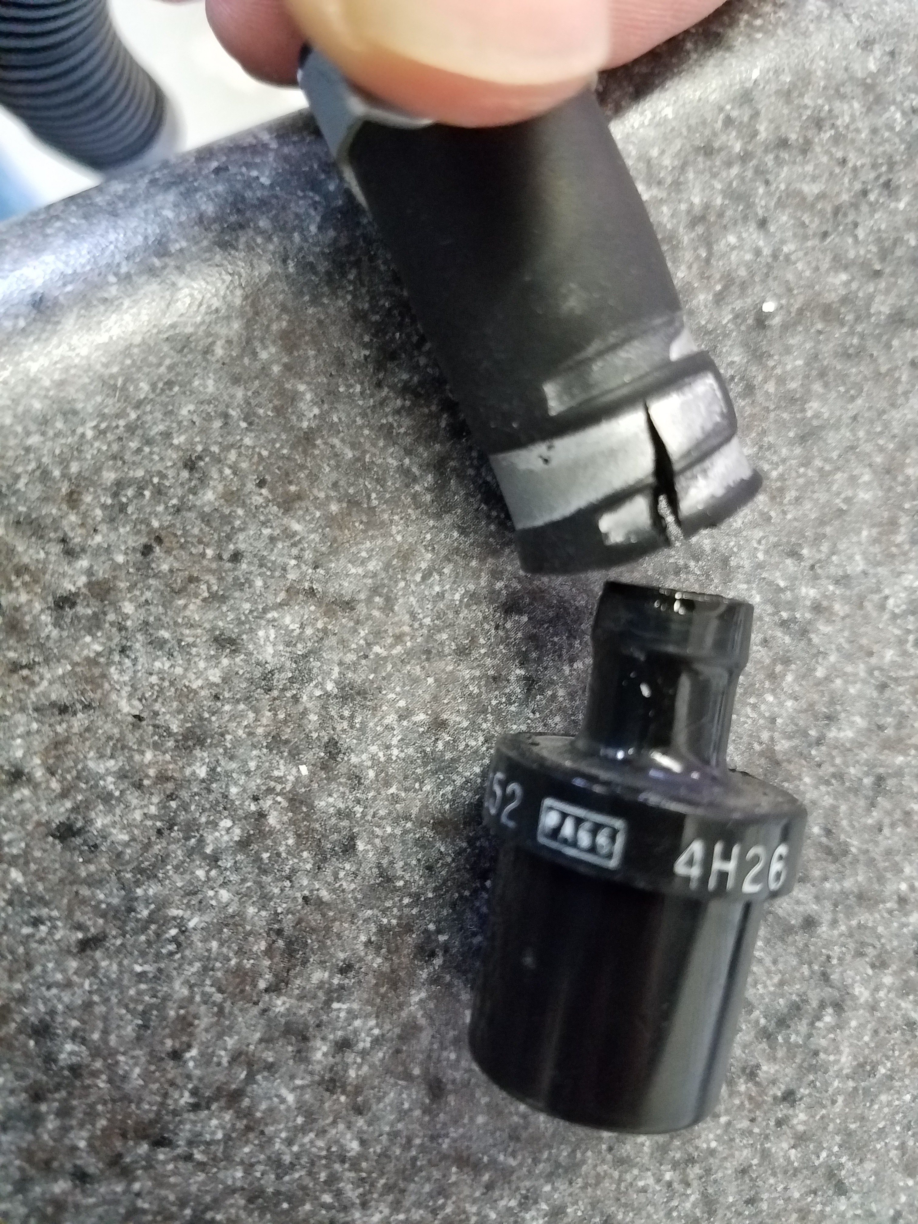 Another view of a damaged upper vacuum hose for a PCV valve in an Aston Martin DB9, highlighting the rubber degradation