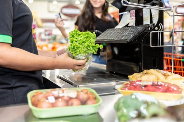 Grocery store worker scanning produce using an RF scanner