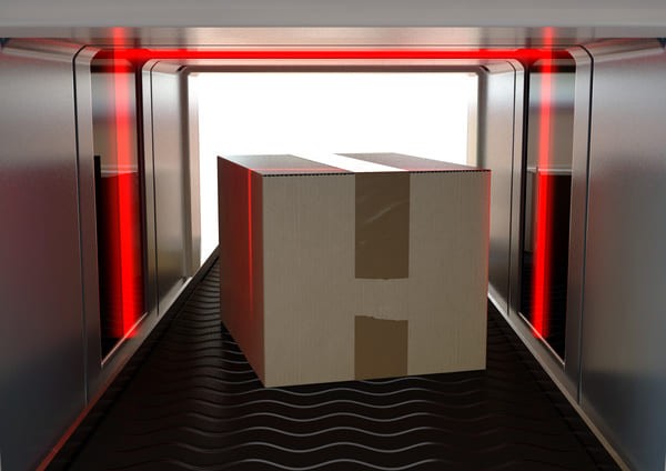 Box moving down a conveyor belt with a laser beam surrounding it