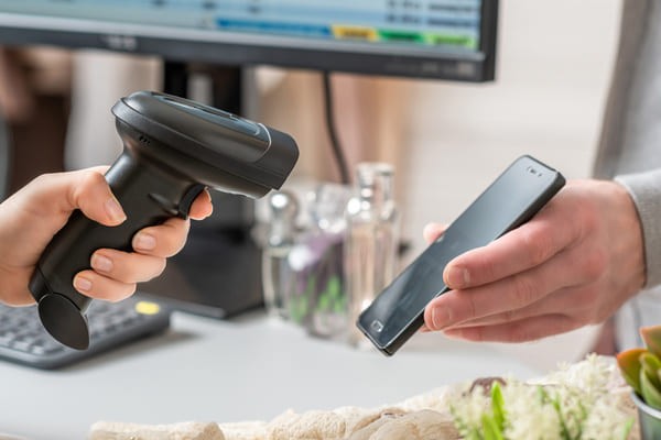 Worker using an RF scanner to scan a smartphone screen
