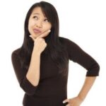 Woman in a medical setting thoughtfully considering sonography as a career choice.