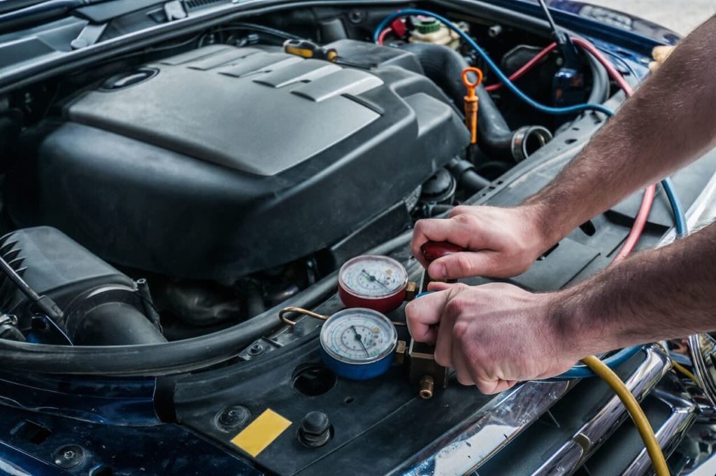 Man recharging car's AC with Freon