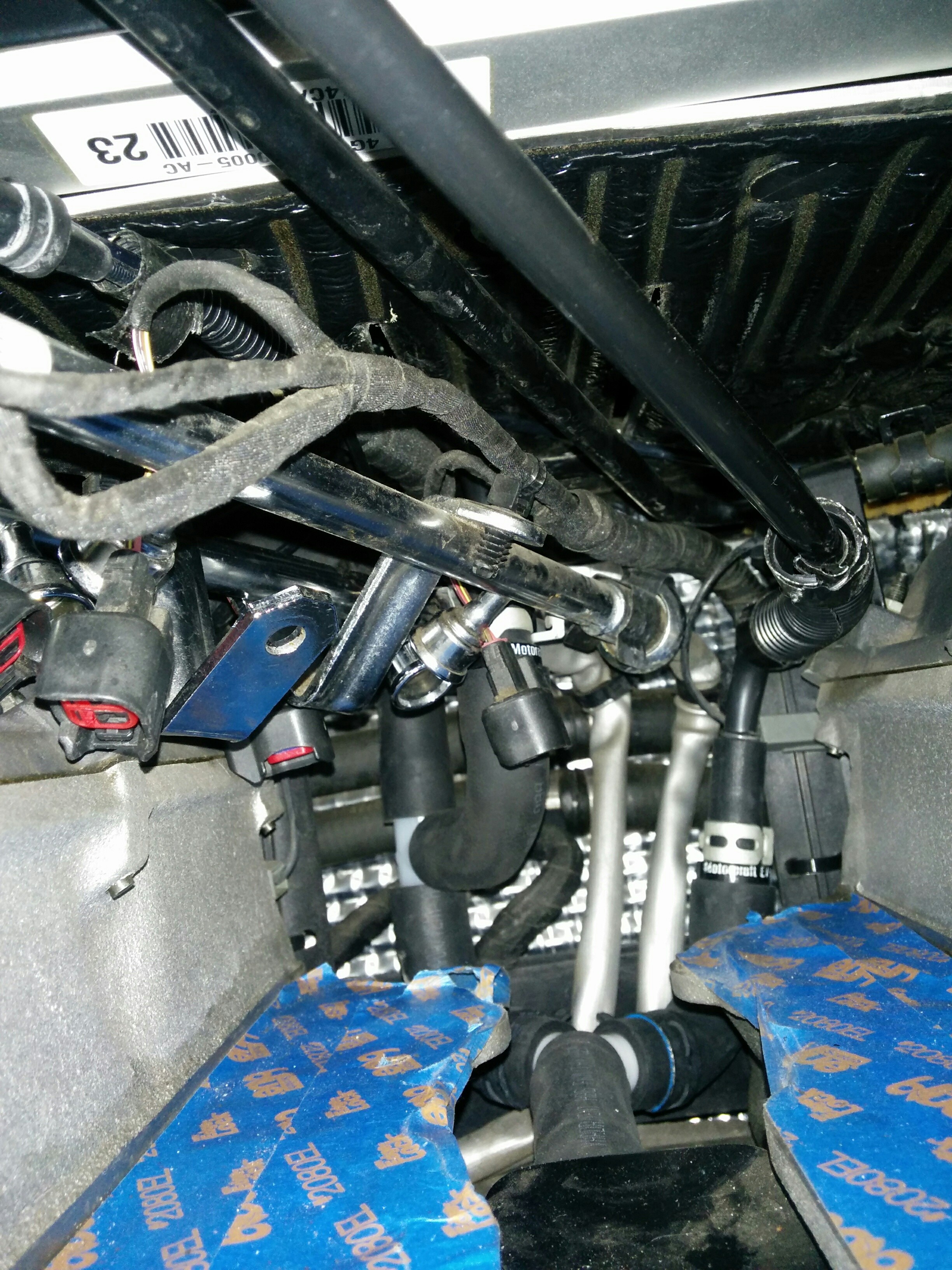 Limited access to PCV valves in an Aston Martin DB9, highlighting the difficulty of manual replacement