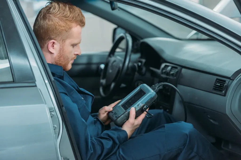 Mechanic Using Auto Diagnostics Tool