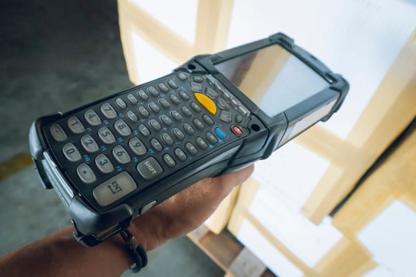 Closeup of a mobile computer scanning a box barcode