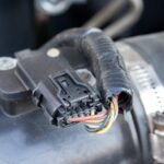Inserting a paperclip into the reset port for MAF sensor reset