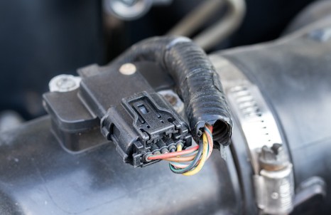 Inserting a paperclip into the reset port for MAF sensor reset