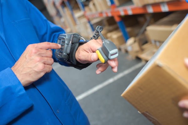 Warehouse worker pressing buttons on a wearable RF scanner