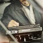 Technician using Panasonic Toughbook for diagnostics in a garage